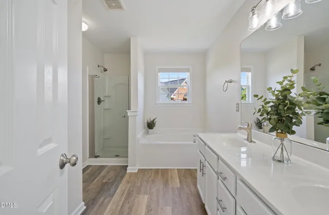 a bathroom with a sink a large mirror a vanity and shower