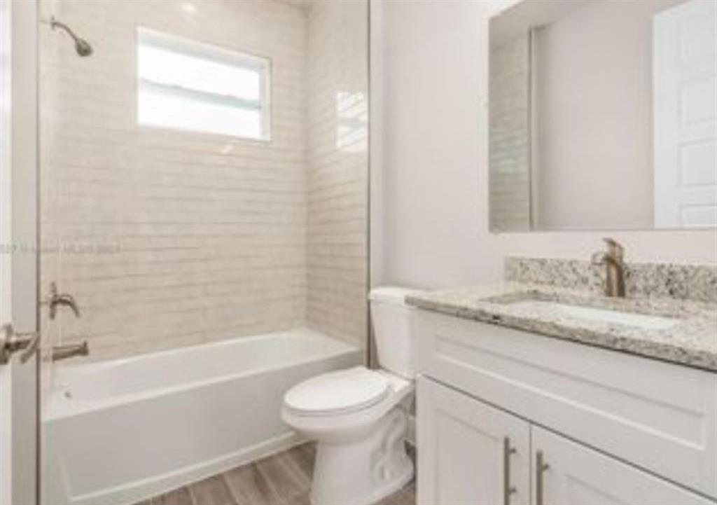 321 Neighborly Road LaBelle, FL 33935 - Photo 14 of 18 a bathroom with a granite countertop toilet a sink and bathtub