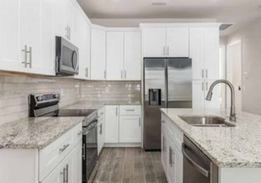 321 Neighborly Road LaBelle, FL 33935 - Photo 17 of 18 a kitchen with granite countertop a sink stainless steel appliances and cabinets