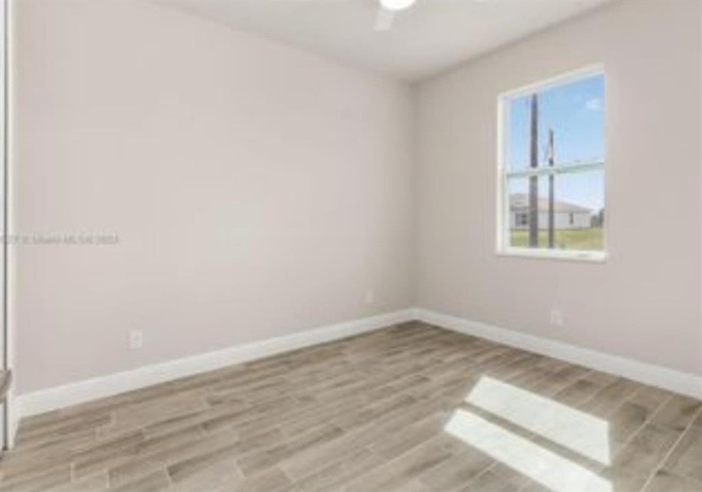 321 Neighborly Road LaBelle, FL 33935 - Photo 10 of 18 an empty room with wooden floor and windows