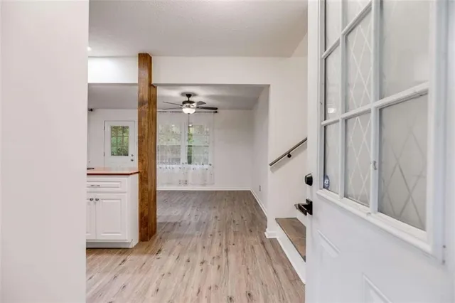 a view of a hallway with wooden floor and staircase