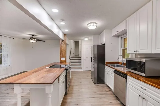 a kitchen with stainless steel appliances granite countertop a refrigerator a stove and a sink