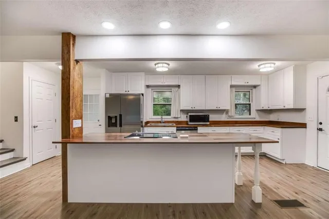 a kitchen with kitchen island a sink a stove and chairs