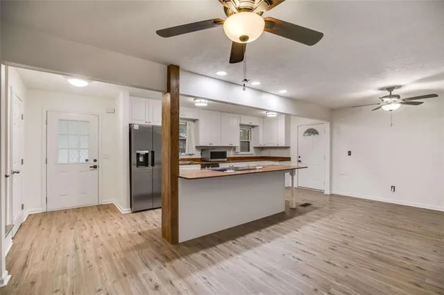 a view of kitchen with sink microwave and refrigerator