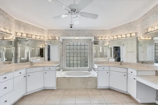 a bathroom with a granite countertop bathtub sink vanity and mirror