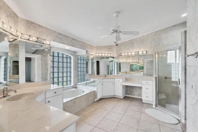 a large white bathroom with a large tub sink shower and mirror