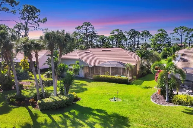 a view of a white house with a big yard and potted plants