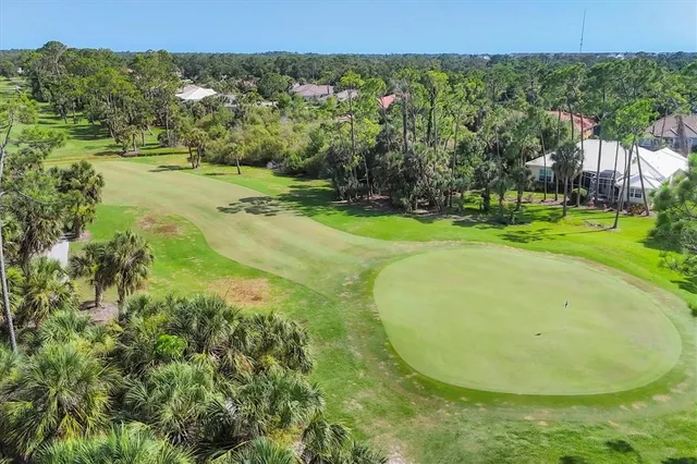 a view of a swimming pool with a yard and large trees