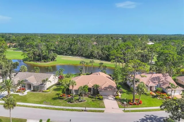 an aerial view of residential houses with outdoor space and trees