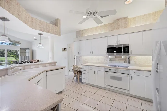 a kitchen with white cabinets appliances and a sink
