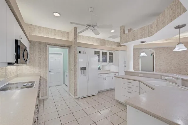 a kitchen with white cabinets and sink