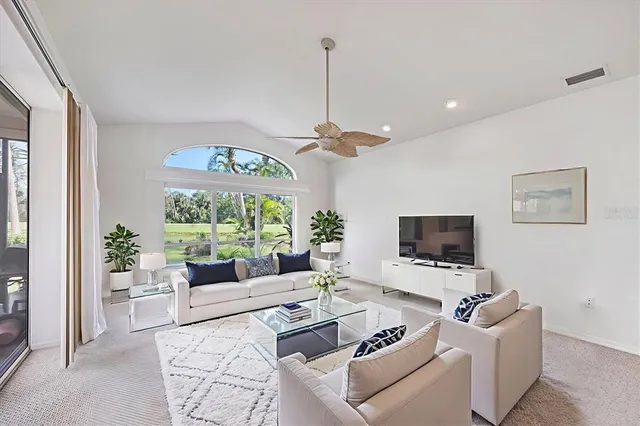 a living room with furniture a floor to ceiling window and a flat screen tv