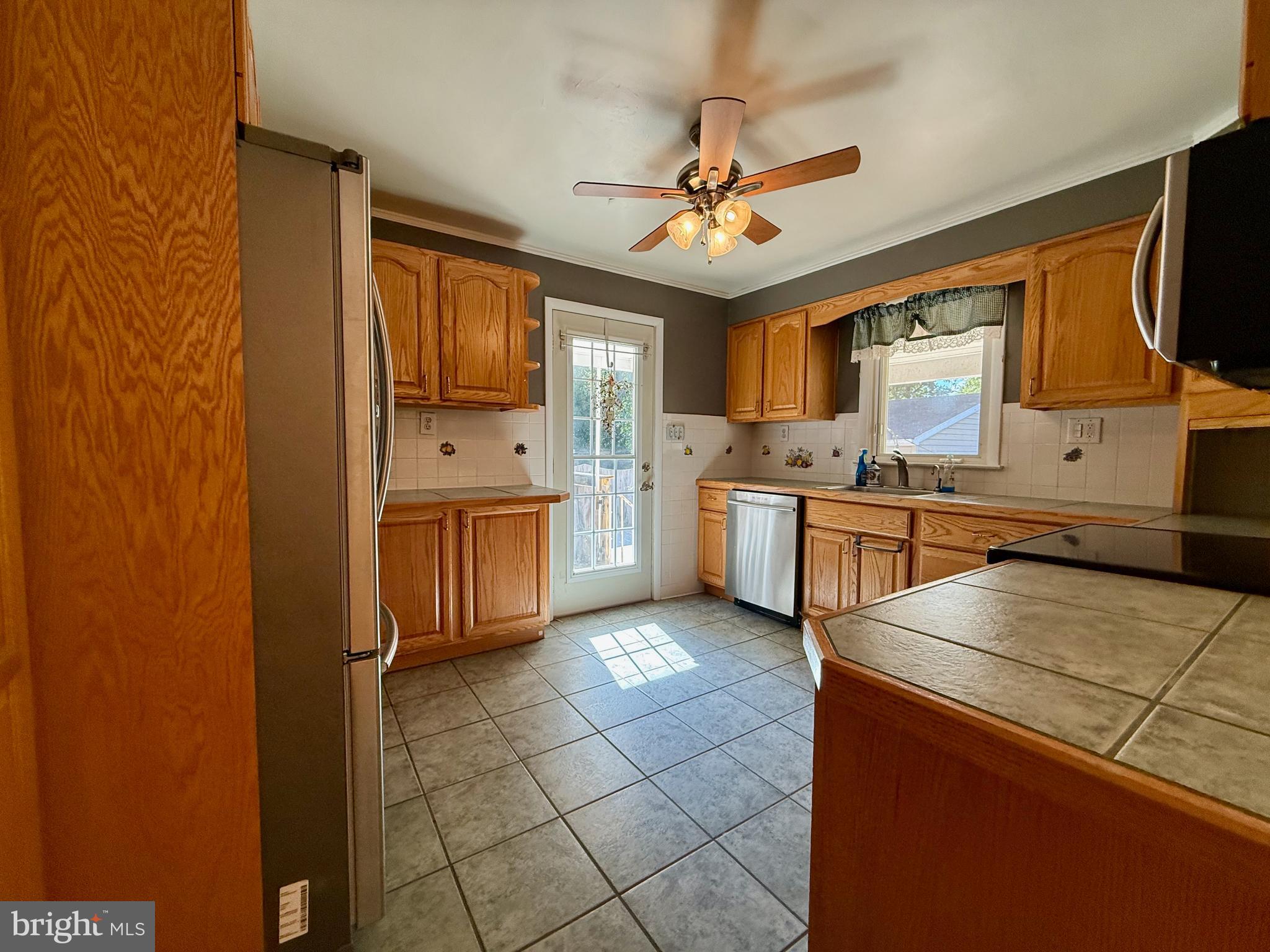 3817 Schroeder Avenue Perry Hall, MD 21128 - Photo 12 of 48 a kitchen with stainless steel appliances a sink a stove a refrigerator cabinets and a window