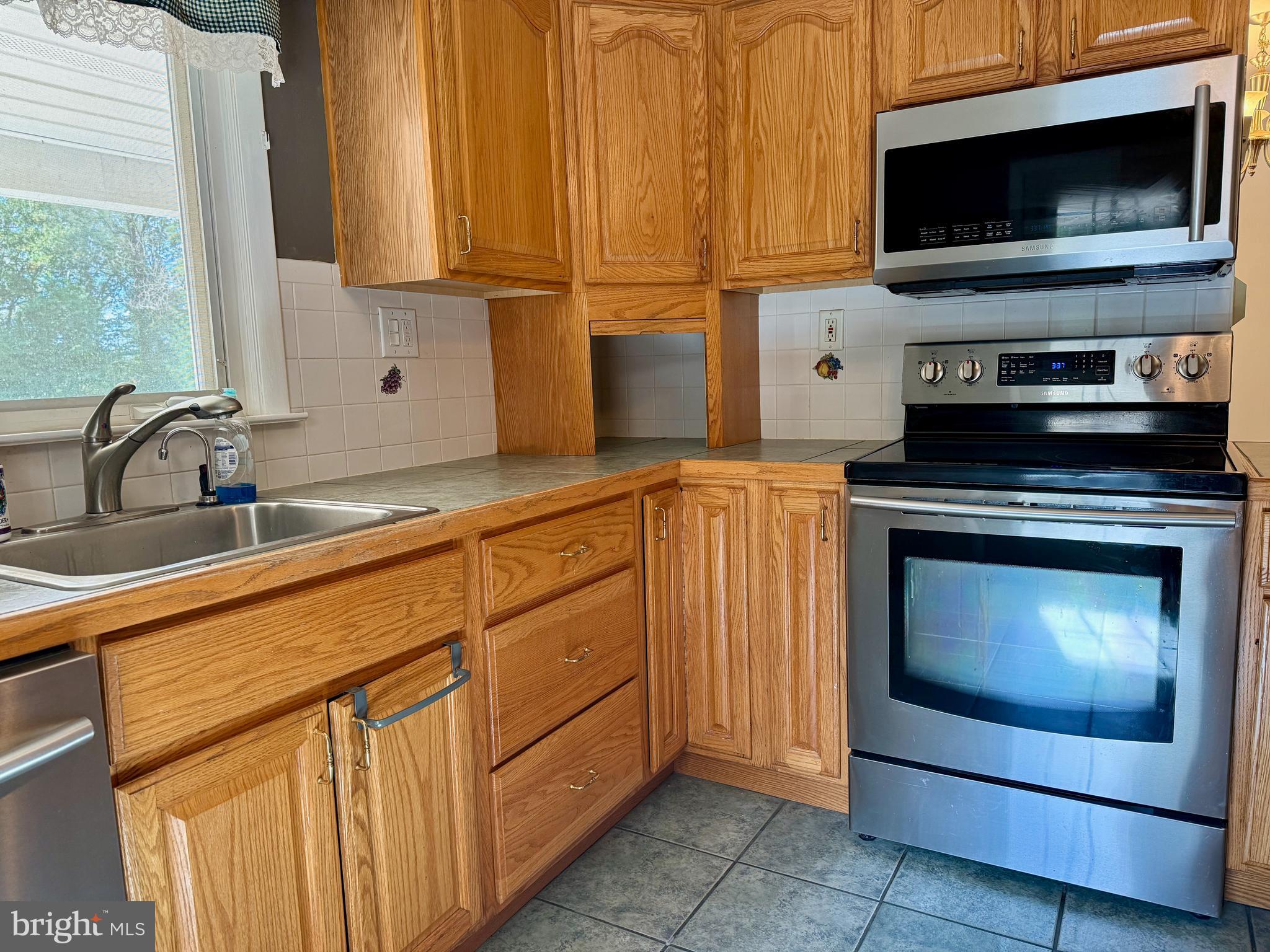 3817 Schroeder Avenue Perry Hall, MD 21128 - Photo 13 of 48 a kitchen with stainless steel appliances a stove a microwave and a sink