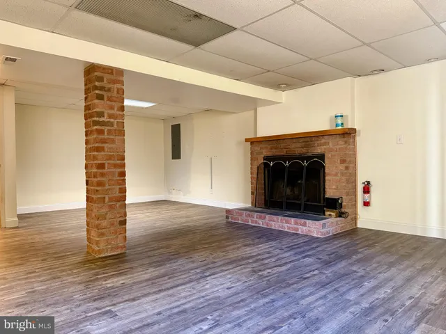 a view of empty room with wooden floor and fireplace
