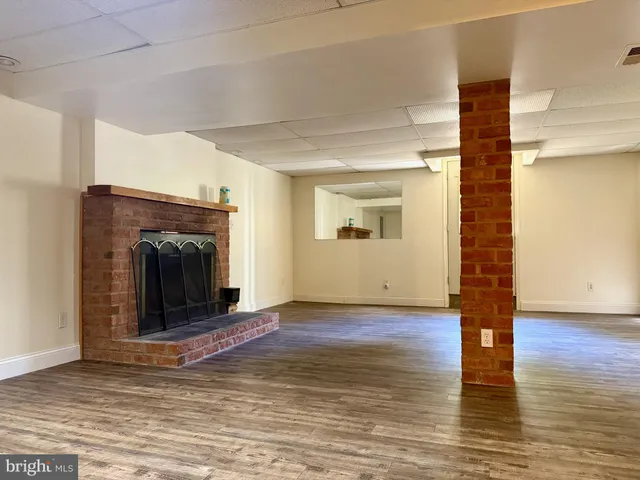 a view of empty room with wooden floor and fireplace