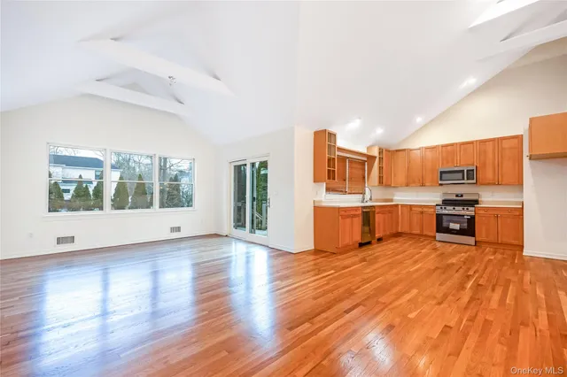 a view of empty room with wooden floor and windows