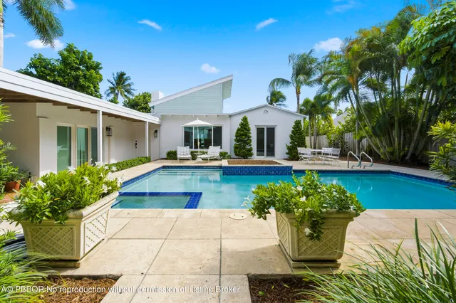 a view of a house with patio furniture and potted plants