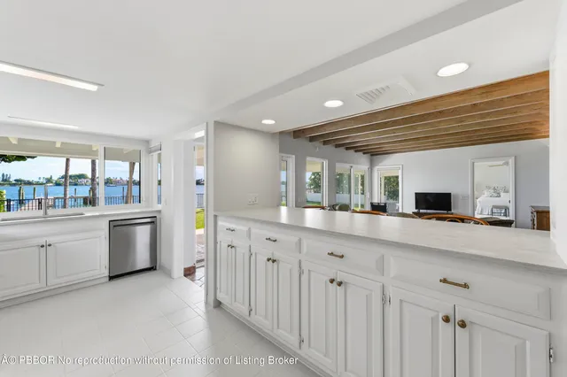 a large white kitchen with a stove top oven a sink and dishwasher