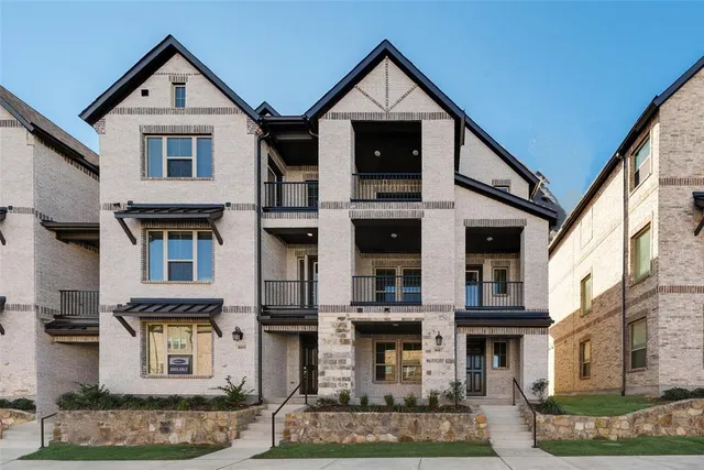 a view of a big house with brick walls and windows