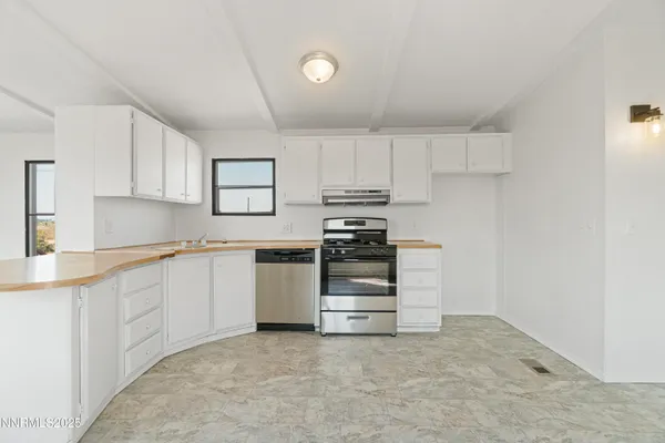 a kitchen with granite countertop white cabinets and appliances
