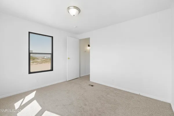 an empty room with windows and closet