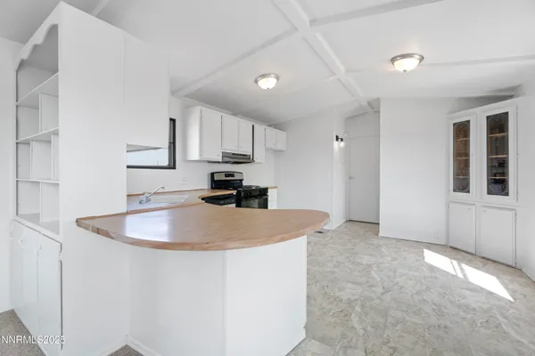 a kitchen with kitchen island a sink stainless steel appliances and white cabinets