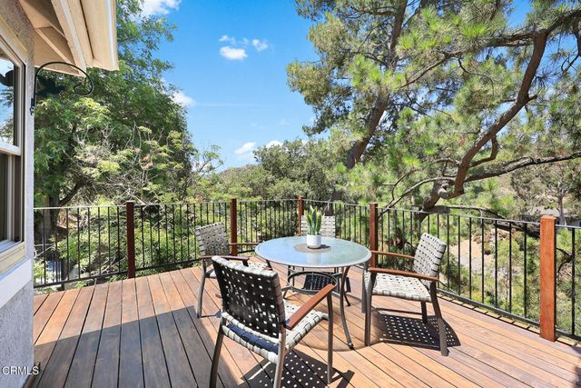 a view of a chairs and table in patio with wooden floor