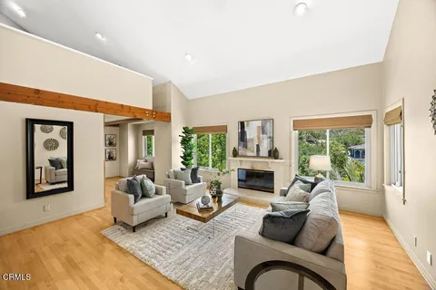 a living room with furniture large window and a fireplace