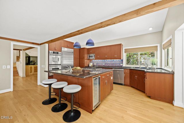 a kitchen with stainless steel appliances granite countertop a sink and a refrigerator