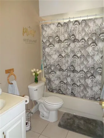 a white toilet sitting next to a shower curtain