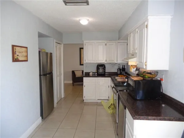 a kitchen with a refrigerator and a stove top oven