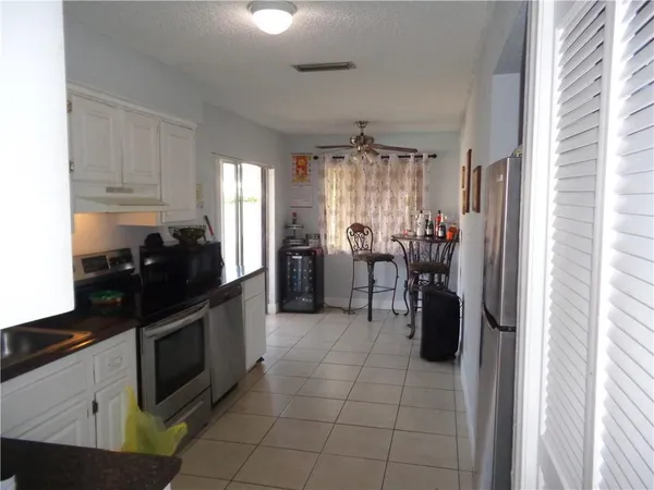 a kitchen with granite countertop a refrigerator and a sink