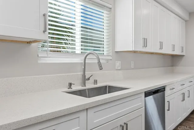 a kitchen with a sink cabinets and a window