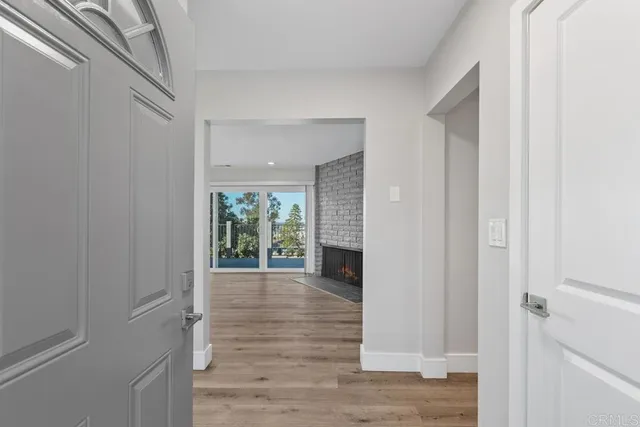 a view of a hallway with wooden floor and a living room