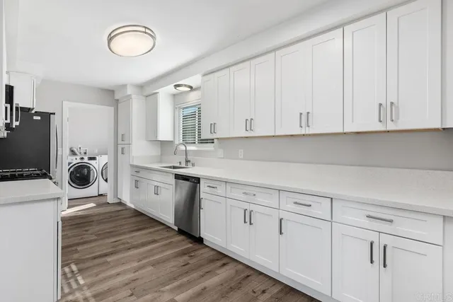 a kitchen with white cabinets and sink