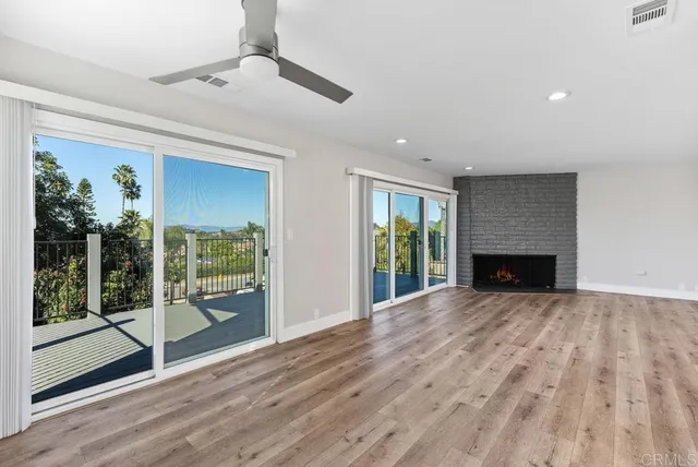 a view of an empty room with glass door and balcony