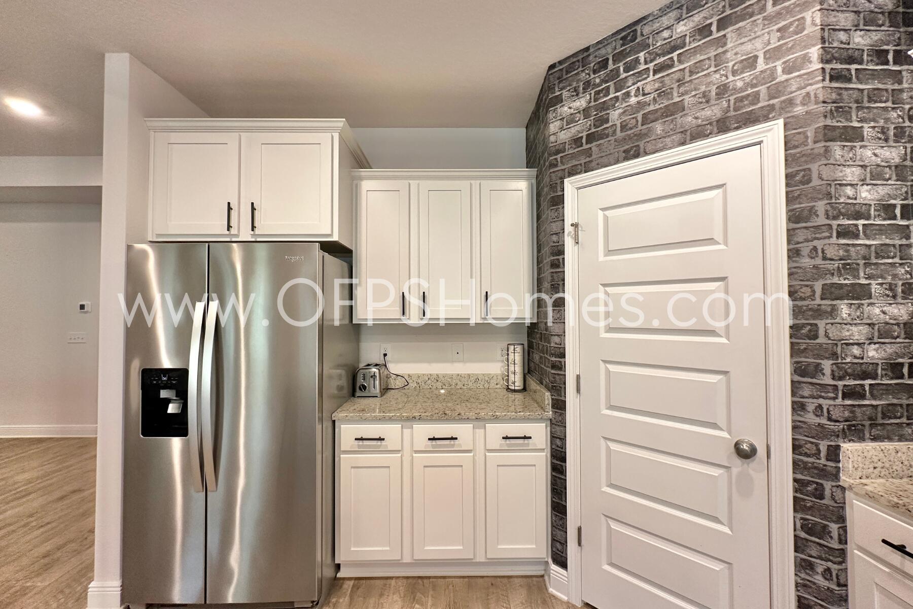 8090 Silver Maple Drive Milton, FL 32583 - Photo 18 of 42 a kitchen with a refrigerator and cabinets