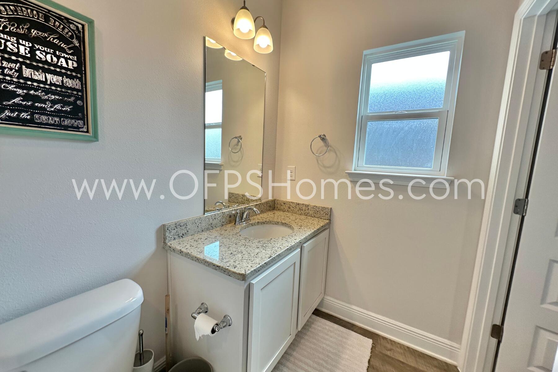 8090 Silver Maple Drive Milton, FL 32583 - Photo 29 of 42 a bathroom with a granite countertop sink and a mirror