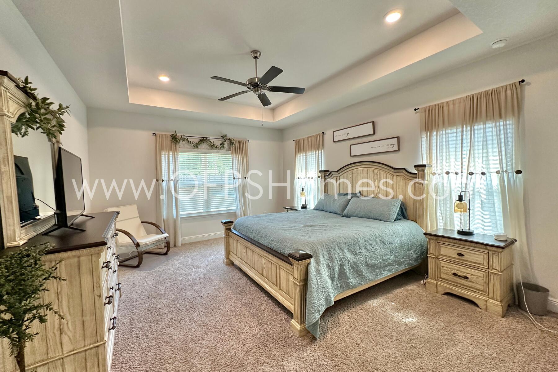 8090 Silver Maple Drive Milton, FL 32583 - Photo 30 of 42 a bedroom with a bed flat screen tv and windows