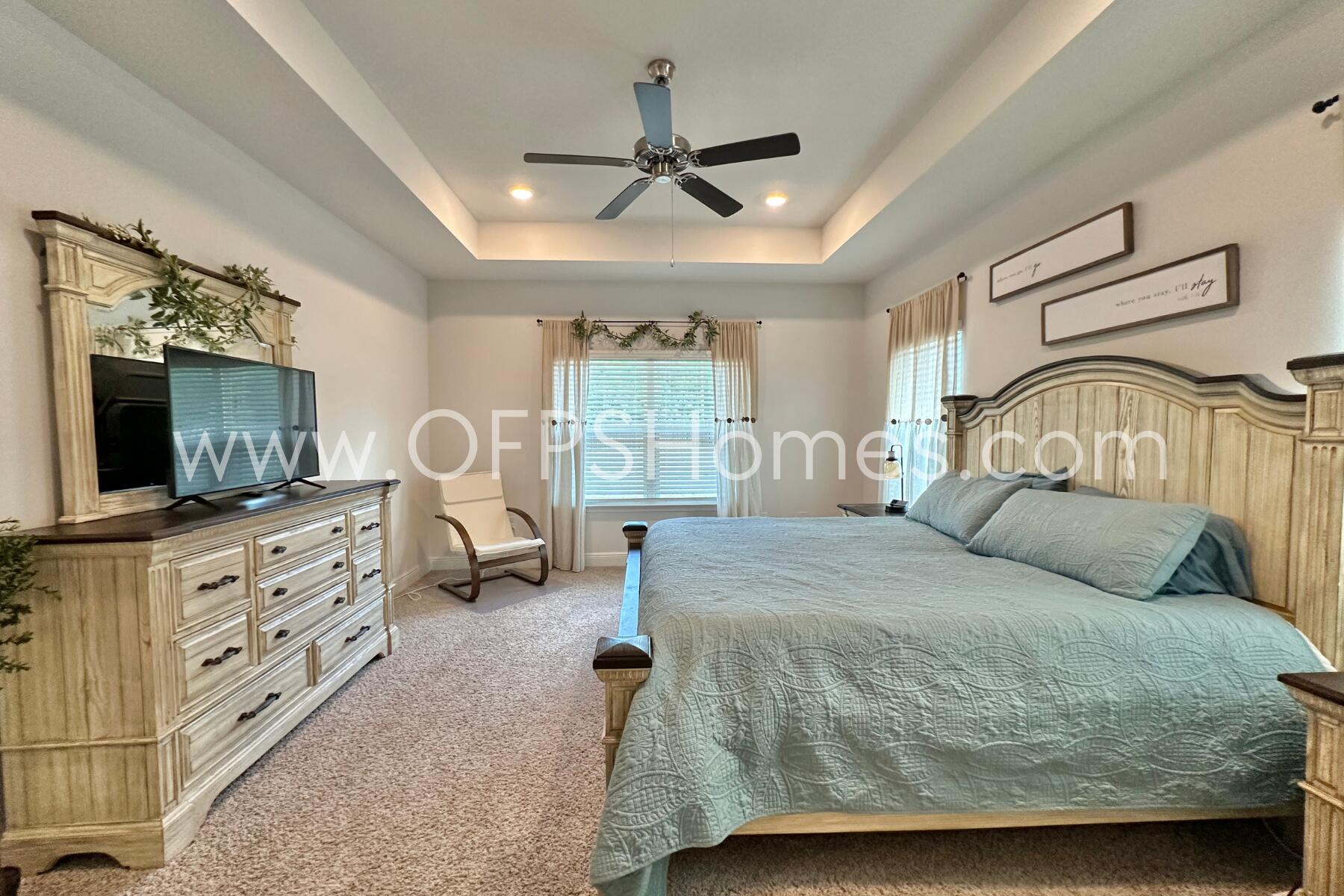 8090 Silver Maple Drive Milton, FL 32583 - Photo 33 of 42 a bedroom with a large bed and a flat tv screen on dresser