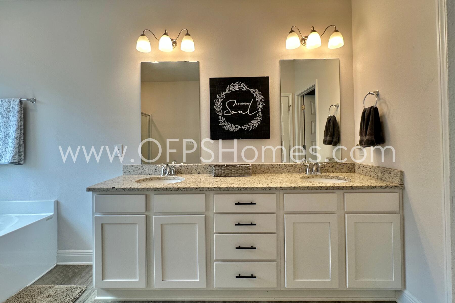 8090 Silver Maple Drive Milton, FL 32583 - Photo 35 of 42 a bathroom with a double vanity sink and a mirror