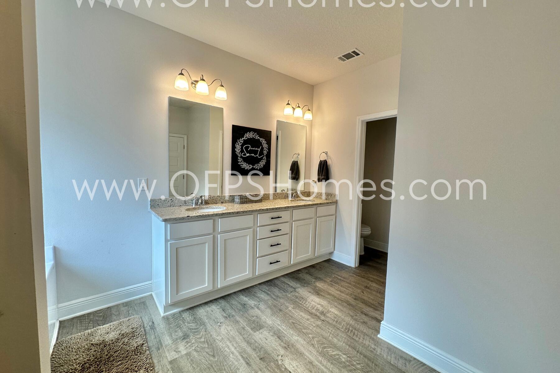 8090 Silver Maple Drive Milton, FL 32583 - Photo 36 of 42 a bathroom with a sink a mirror and a shower