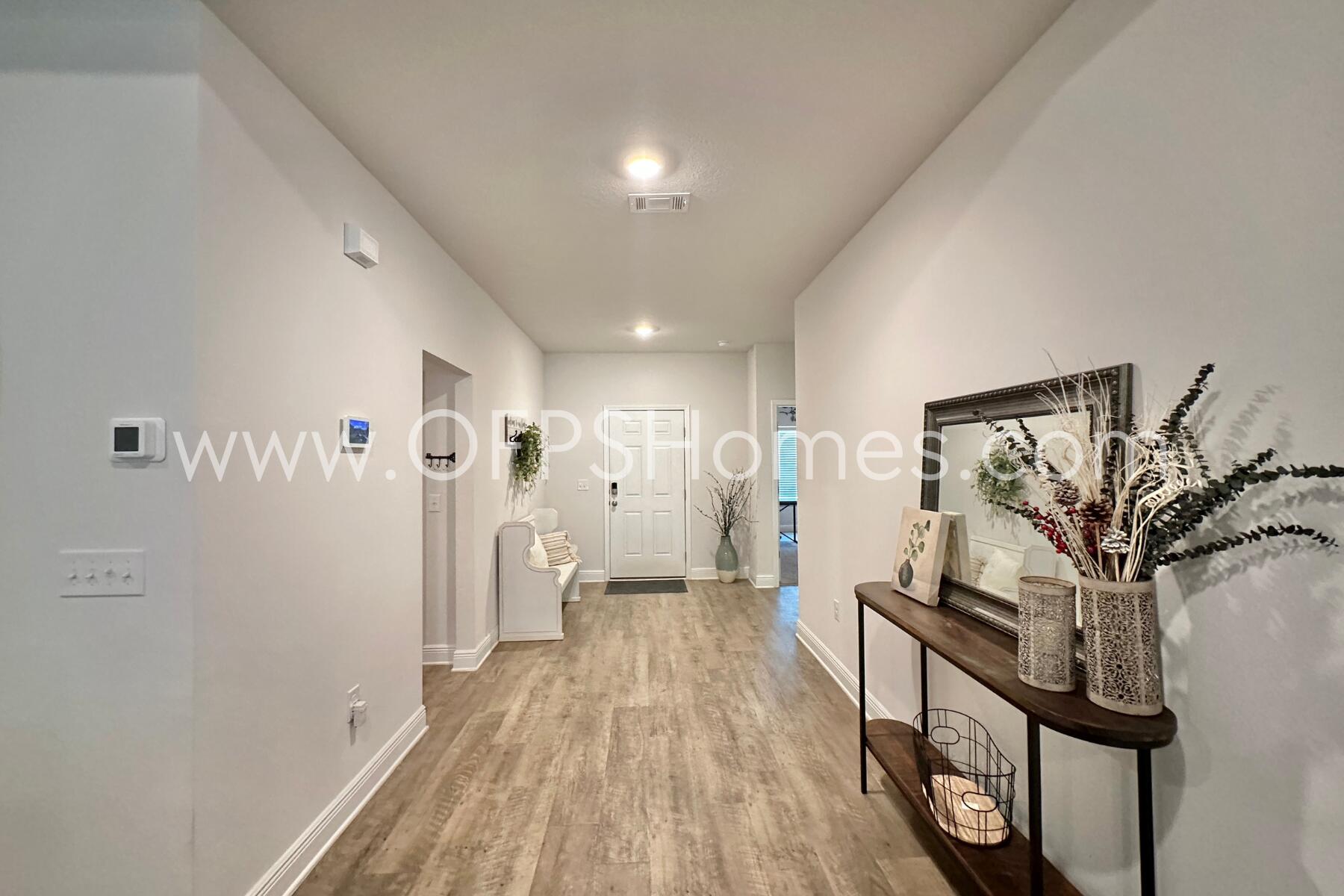 8090 Silver Maple Drive Milton, FL 32583 - Photo 7 of 42 a view of a hallway with wooden floor and staircase