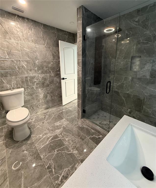 14273 Nugent Circle Spring Hill, FL 34609 - Photo 12 of 27 a bathroom with a sink and a shower