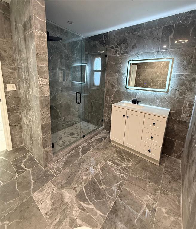 14273 Nugent Circle Spring Hill, FL 34609 - Photo 13 of 27 a spacious bathroom with a sink a mirror and a shower