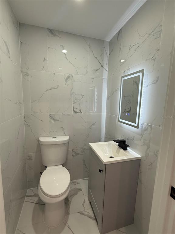 14273 Nugent Circle Spring Hill, FL 34609 - Photo 21 of 27 a bathroom with a toilet sink and mirror