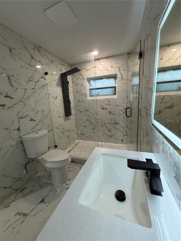 14273 Nugent Circle Spring Hill, FL 34609 - Photo 26 of 27 a bathroom with a sink a toilet and shower