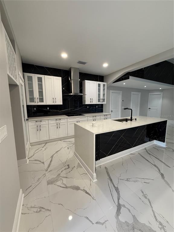 14273 Nugent Circle Spring Hill, FL 34609 - Photo 6 of 27 a large white kitchen with stainless steel appliances kitchen island granite countertop a sink and cabinets