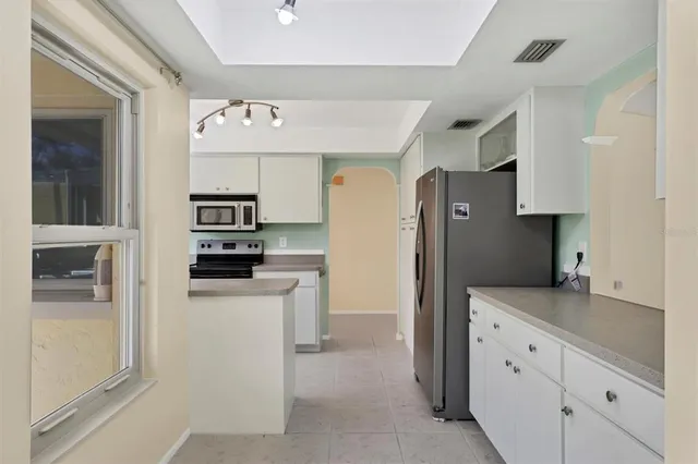 a kitchen with stainless steel appliances granite countertop a refrigerator and a stove